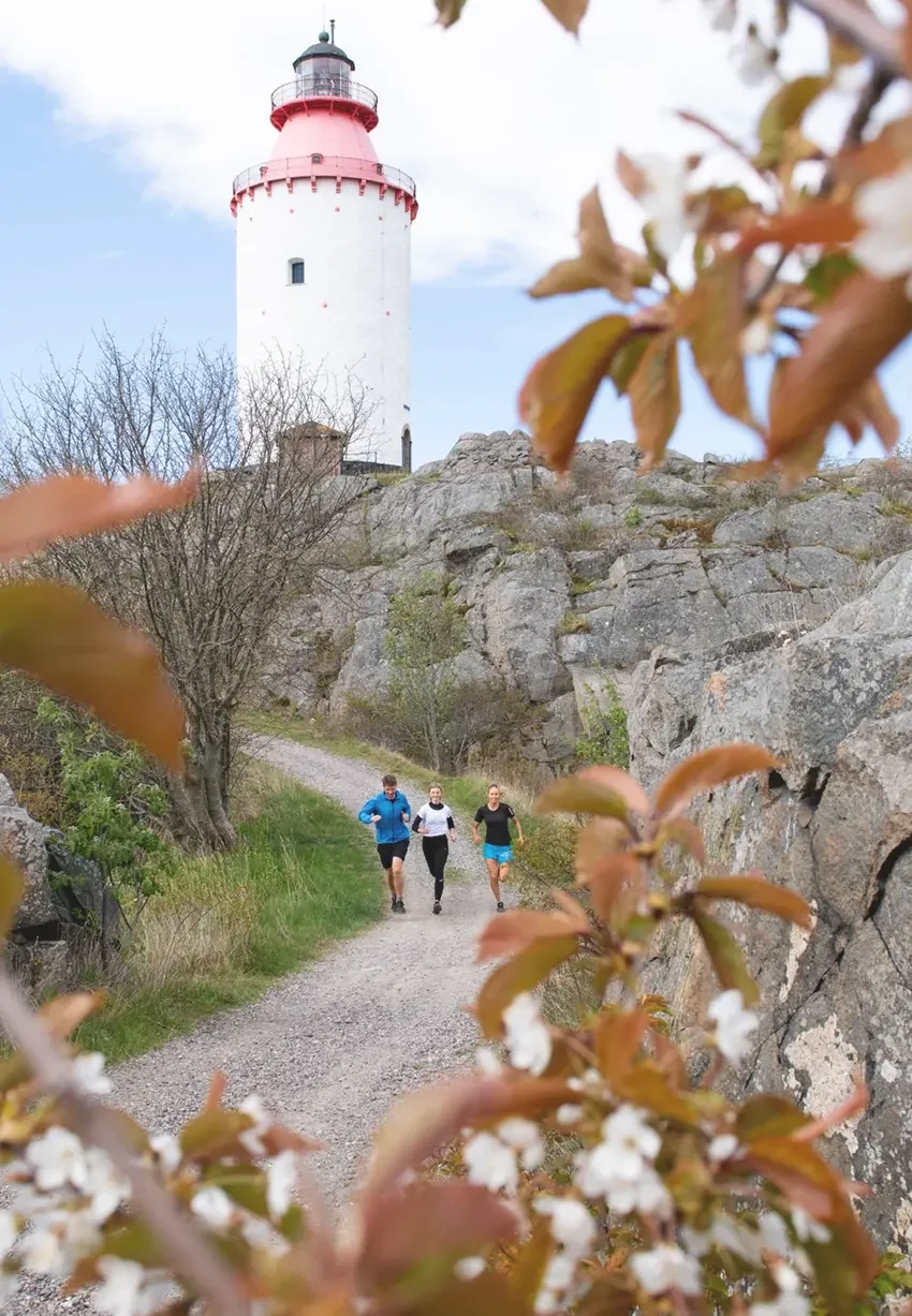 landsort Landsort, tre personer joggar på grusvägen nedanför fyren. photo: Lars Sjöqvist/imagebank.sweden.se