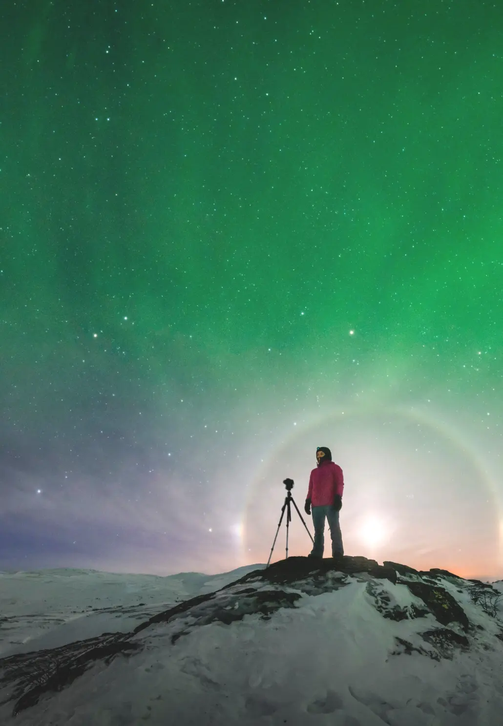 1northern_lights-photographer a person stands with his camera at the top of the mountain in the northern lights. photo: Göran Strand/imagebank.sweden.se