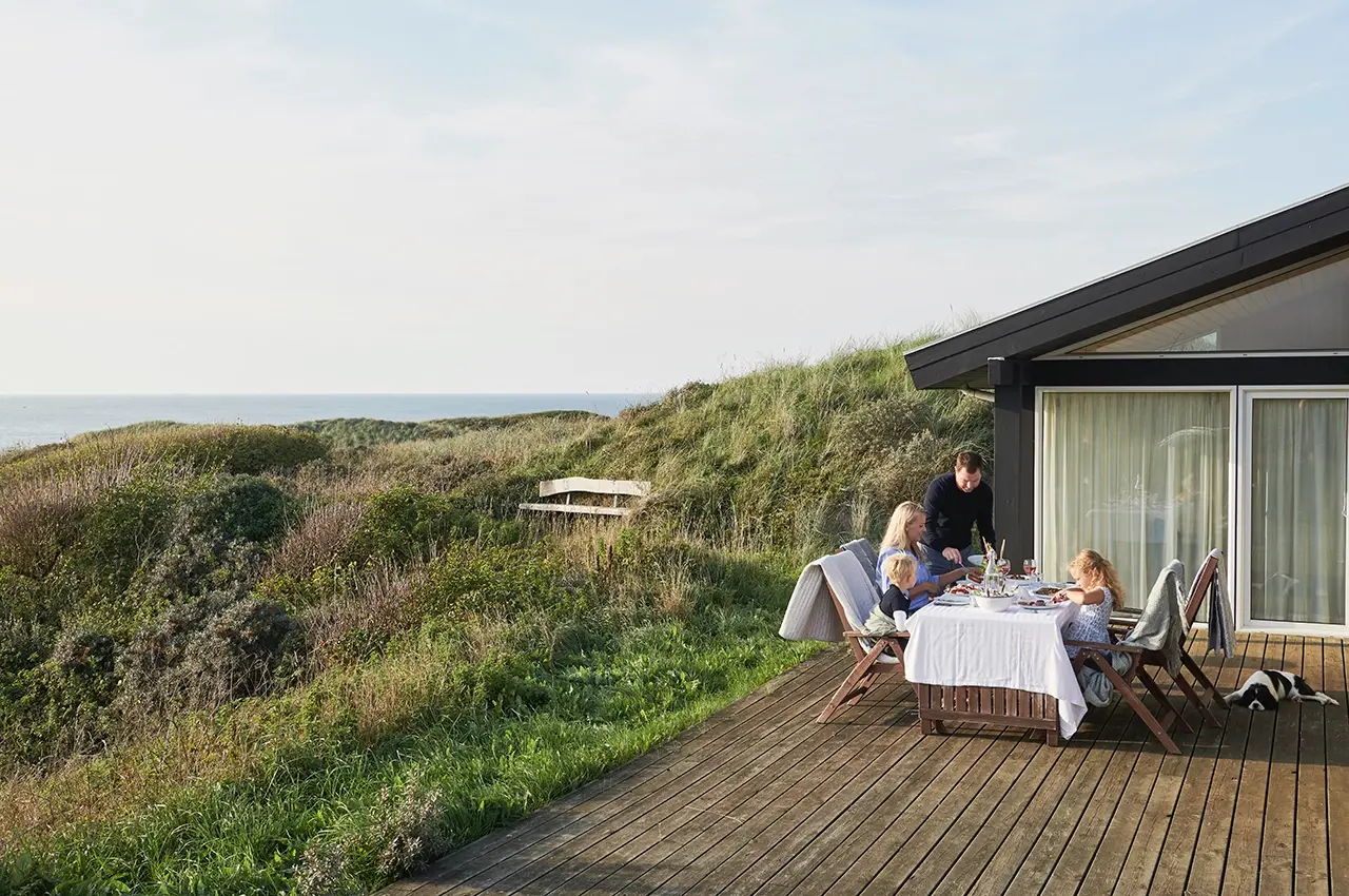Hirtshals Hirtshals - family sitting outdoor for dinner with the sea in the background