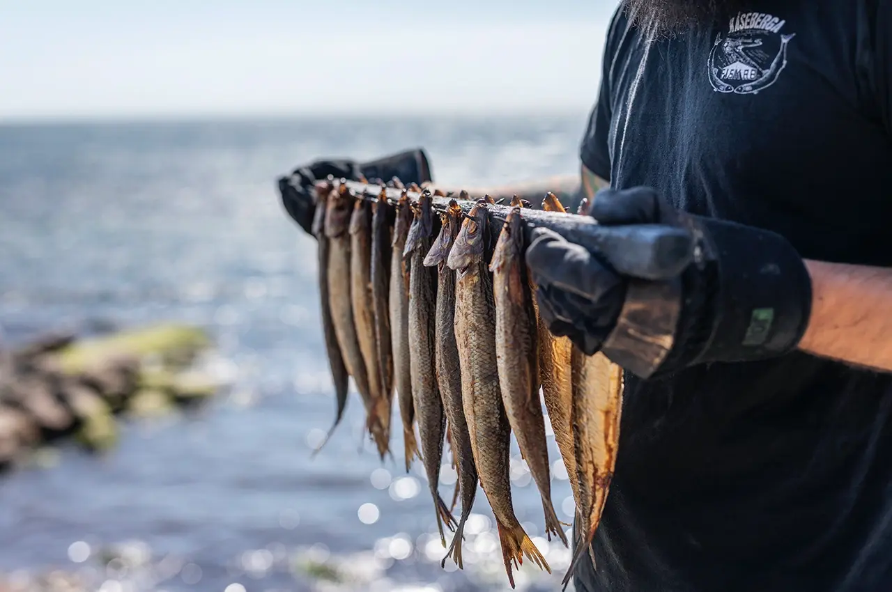 man holding smoked fish att Kåseberga, Skåne