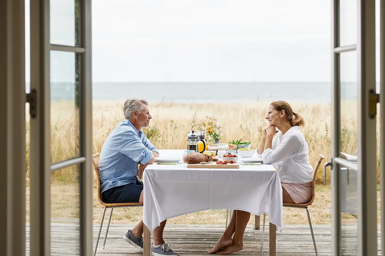 couple having breakfast on the outdoor terass nearby the sea. photo: Robin Skjoldborg